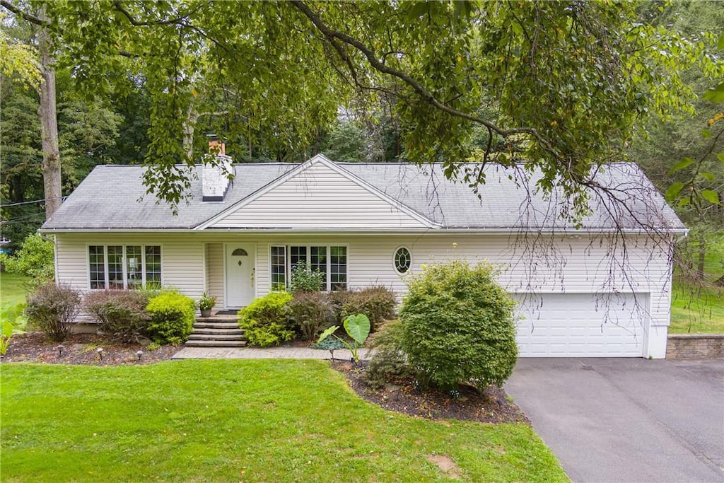 view of front of house with a garage and a front yard