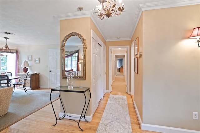 hallway featuring an inviting chandelier, plenty of natural light, crown molding, and light hardwood / wood-style flooring