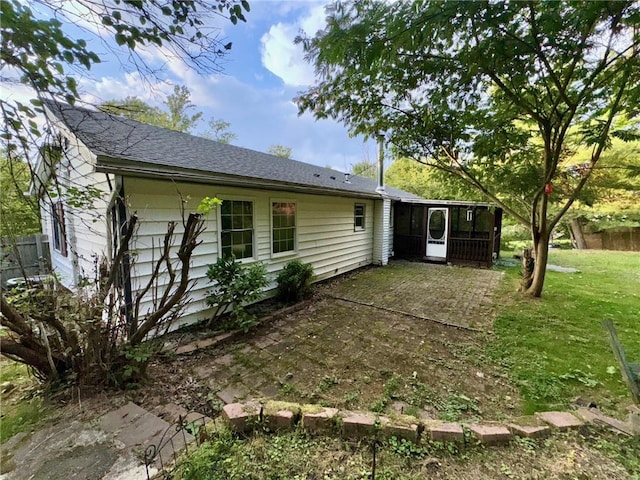 back of property featuring a yard and a sunroom