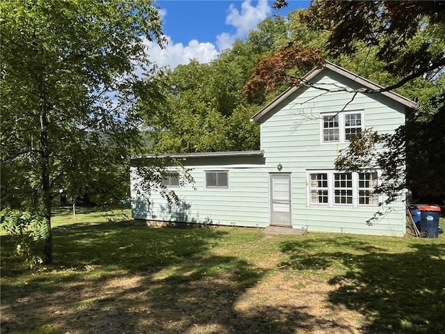 rear view of house featuring a yard