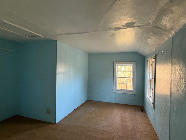 carpeted spare room featuring lofted ceiling