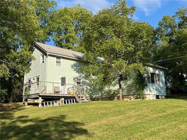 back of property featuring a yard and a deck