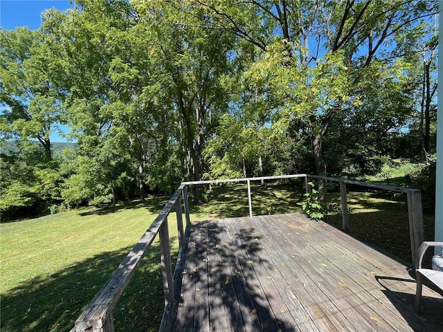 wooden deck featuring a lawn