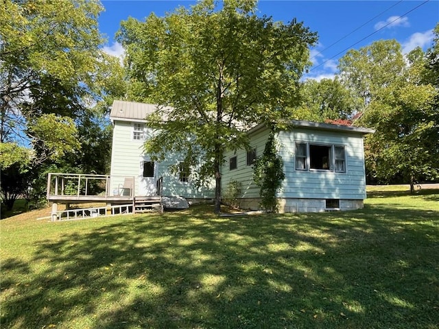 rear view of house with a deck and a lawn