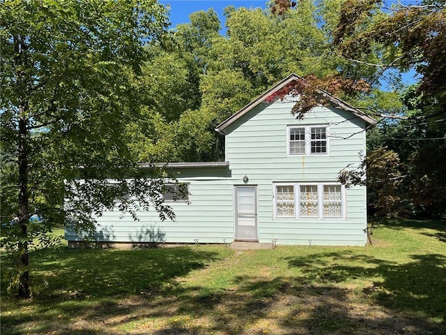 back of property featuring a lawn