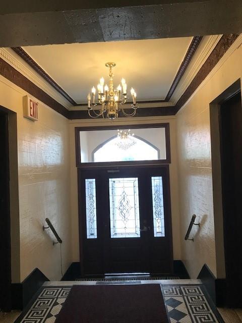 entrance foyer featuring crown molding and a notable chandelier