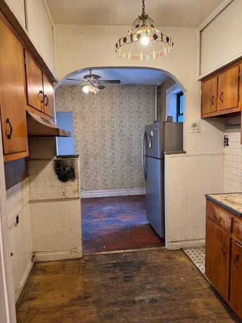 kitchen with dark hardwood / wood-style flooring, tasteful backsplash, ceiling fan, decorative light fixtures, and stainless steel refrigerator