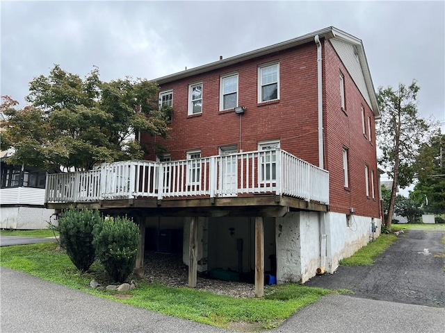 rear view of property featuring a wooden deck