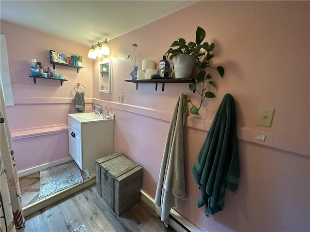 bathroom with vanity, wood-type flooring, and a baseboard heating unit