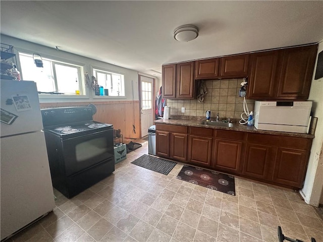 kitchen featuring sink, white appliances, plenty of natural light, and backsplash