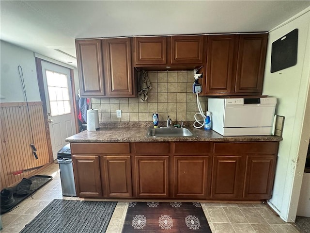 kitchen with light tile patterned flooring, sink, and tasteful backsplash