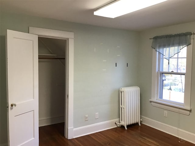 unfurnished bedroom featuring dark hardwood / wood-style flooring, a closet, and radiator