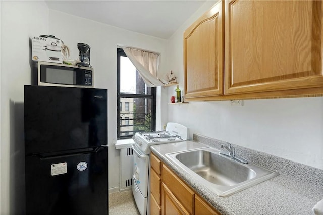 kitchen with black fridge, gas range gas stove, and sink