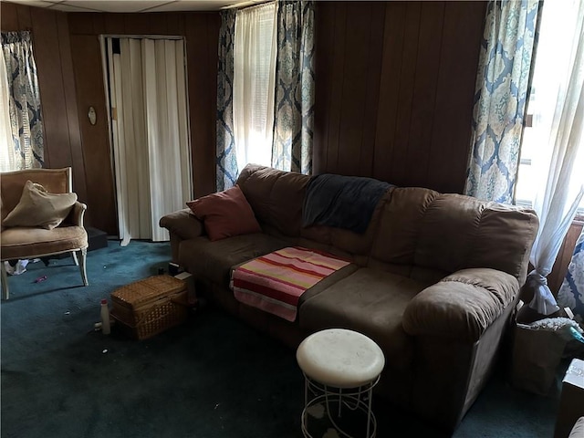 carpeted living room with wooden walls