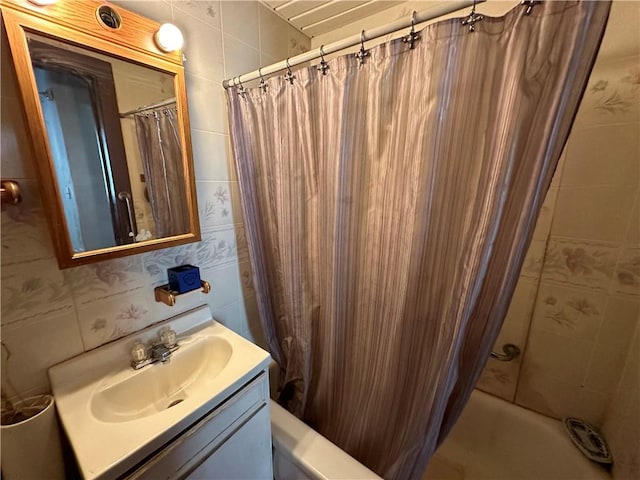 bathroom featuring vanity, shower / bath combination with curtain, and tile walls