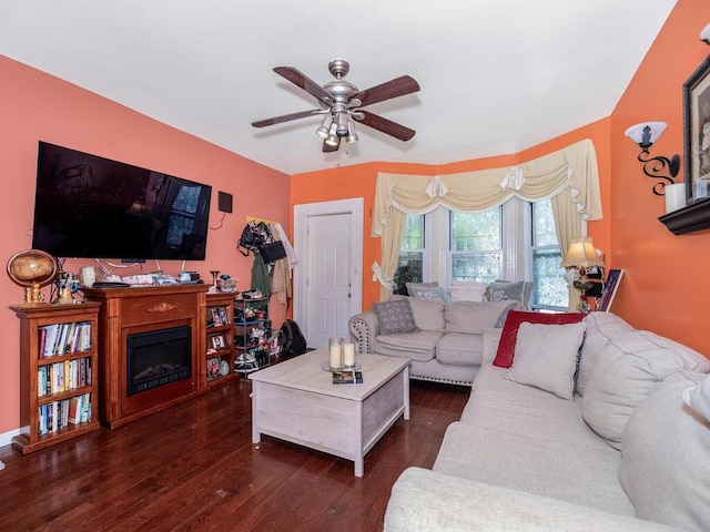 living room with ceiling fan and dark wood-type flooring