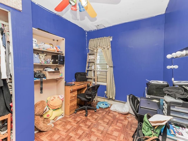 home office with light parquet flooring, a baseboard radiator, and ceiling fan