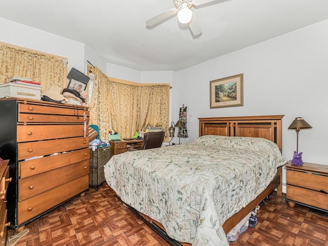 bedroom with dark parquet floors and ceiling fan