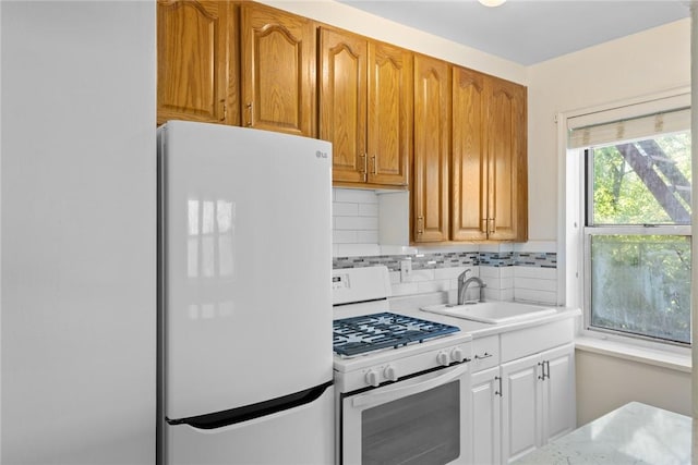 kitchen featuring white appliances, tasteful backsplash, and sink