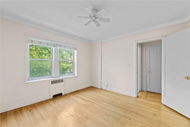 spare room with light hardwood / wood-style flooring, radiator, and ceiling fan