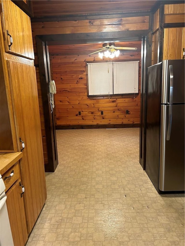 110 Foss Ln, Huguenot, NY 12746 - kitchen with freestanding refrigerator, light floors, wooden walls, and brown cabinets