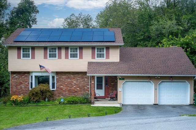 29 Hillview Dr, Poughkeepsie, NY 12603 - view of front facade with an attached garage, asphalt driveway, roof mounted solar panels, and a front yard