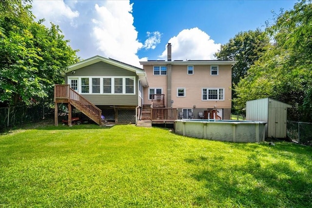 back of property with a swimming pool side deck, a yard, a storage shed, and a sunroom