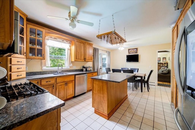 kitchen with stainless steel appliances, ceiling fan, sink, light tile patterned floors, and a center island