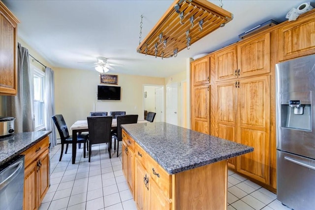 29 Hillview Dr, Poughkeepsie, NY 12603 - kitchen featuring appliances with stainless steel finishes, a center island, light tile patterned floors, a ceiling fan, and dark stone counters