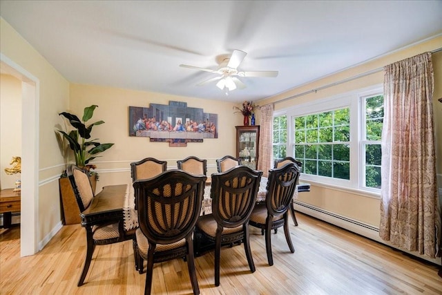 dining area featuring ceiling fan, a baseboard radiator, and light hardwood / wood-style flooring