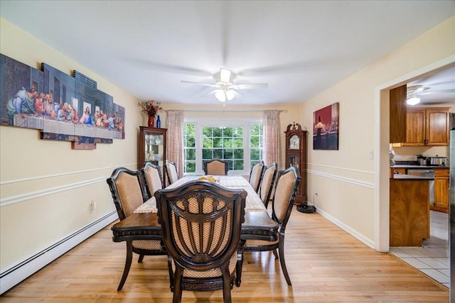 dining room featuring light hardwood / wood-style floors, baseboard heating, and ceiling fan