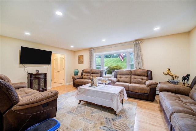 living room with light hardwood / wood-style flooring and a baseboard heating unit