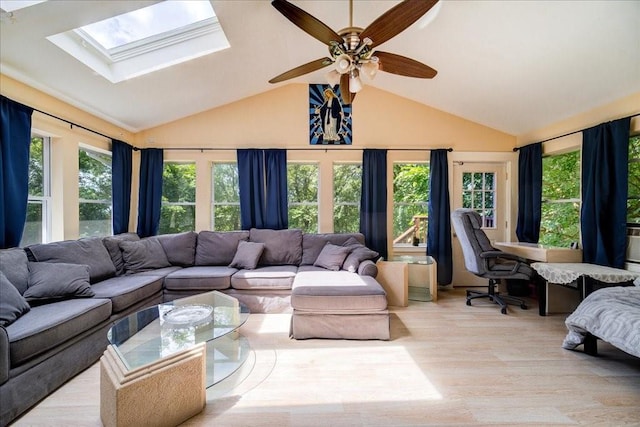 interior space with lofted ceiling with skylight, light hardwood / wood-style flooring, and ceiling fan