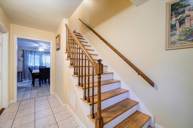 stairs with tile patterned floors and ceiling fan