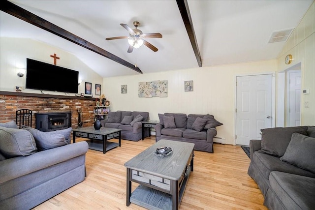 living room featuring vaulted ceiling with beams, a wood stove, a baseboard radiator, and light hardwood / wood-style flooring