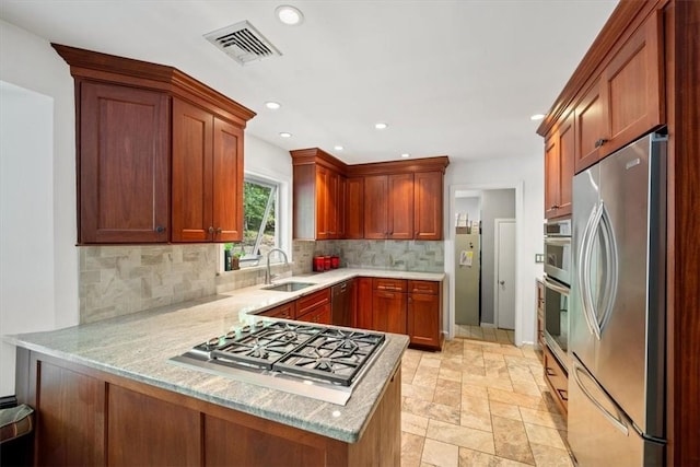 kitchen featuring backsplash, sink, light stone counters, kitchen peninsula, and stainless steel appliances