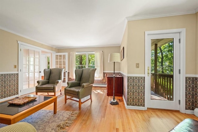 interior space featuring crown molding, a baseboard heating unit, and light wood-type flooring