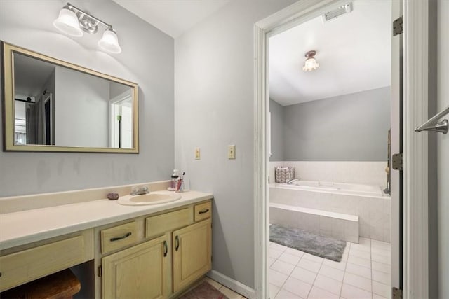 bathroom featuring vanity, tiled bath, and tile patterned floors