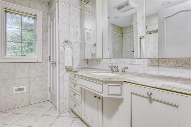 bathroom with tile patterned flooring, vanity, and tile walls