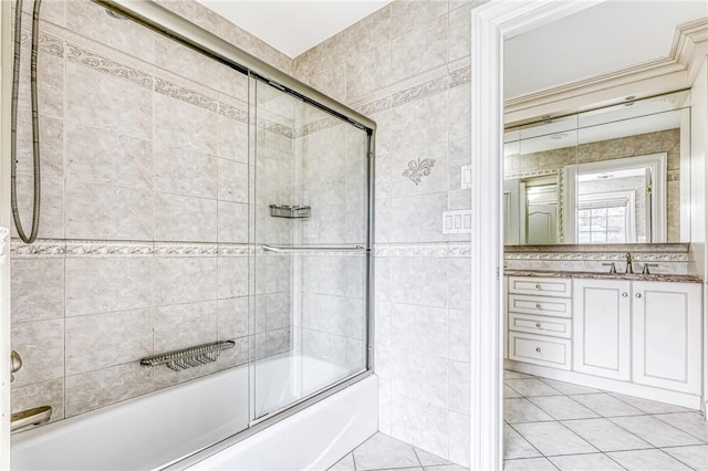 bathroom featuring tile patterned flooring, vanity, and shower / bath combination with glass door