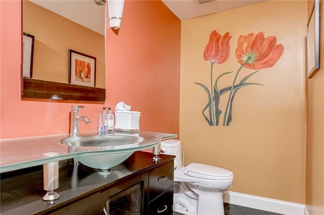 bathroom featuring tile patterned floors, vanity, and toilet