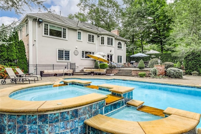 view of pool with outdoor lounge area, an in ground hot tub, and a patio