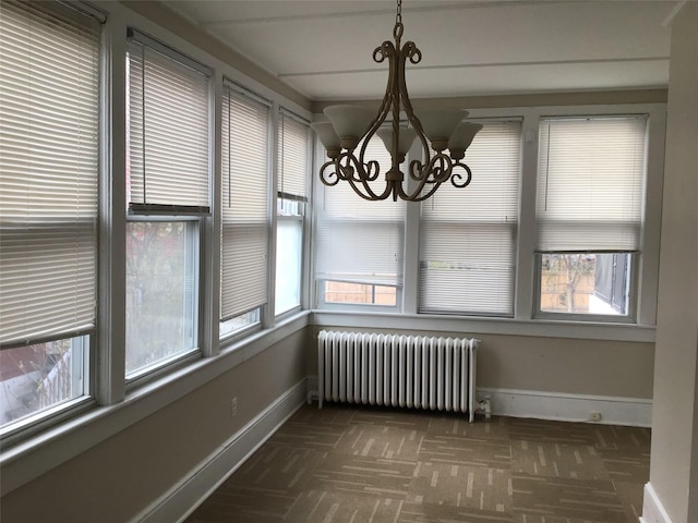 unfurnished dining area featuring radiator heating unit and a notable chandelier