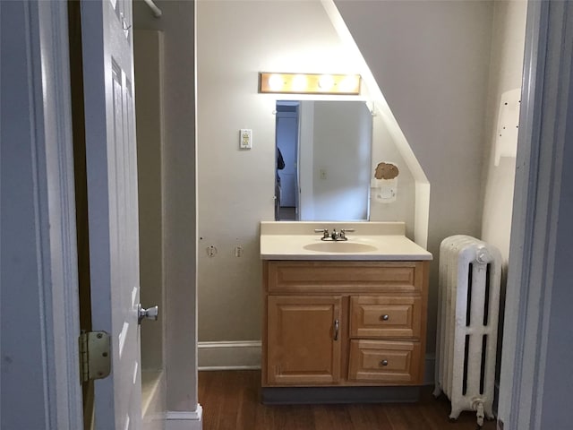 bathroom with radiator, vanity, and wood-type flooring