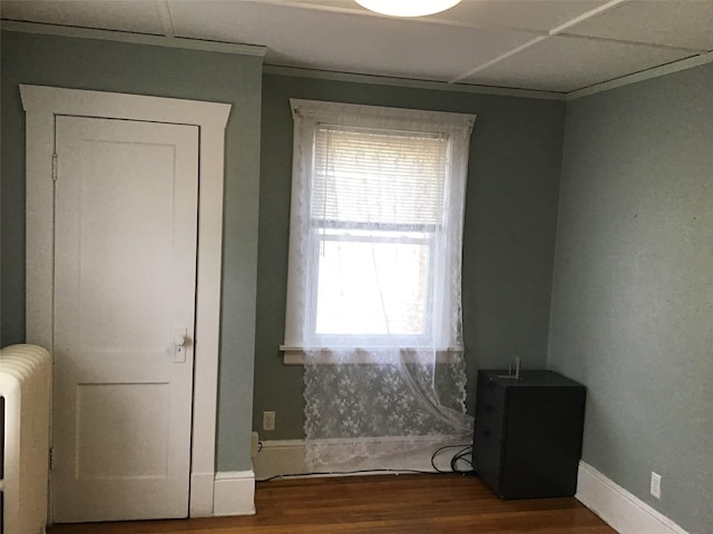 interior space featuring radiator, a paneled ceiling, hardwood / wood-style floors, and plenty of natural light