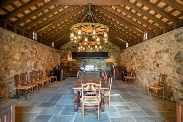 wine cellar featuring beamed ceiling, high vaulted ceiling, and an inviting chandelier