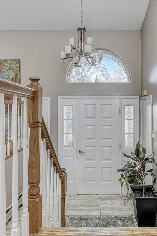 foyer entrance with an inviting chandelier and a baseboard heating unit