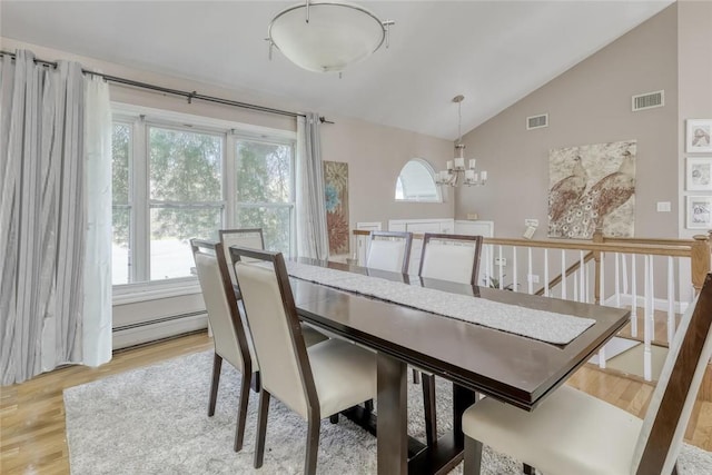 dining area with a chandelier, a baseboard heating unit, light hardwood / wood-style floors, and lofted ceiling