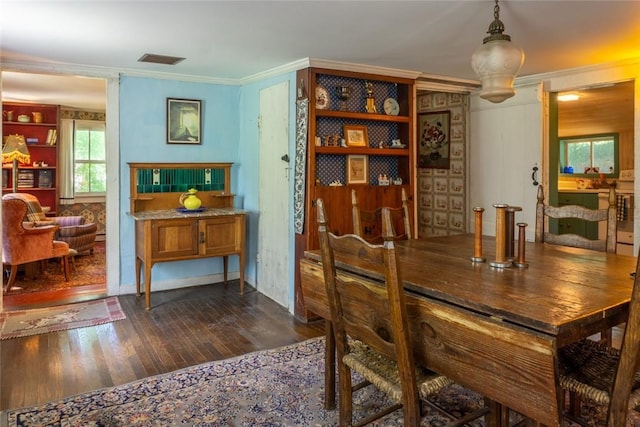 dining space with dark hardwood / wood-style floors and crown molding