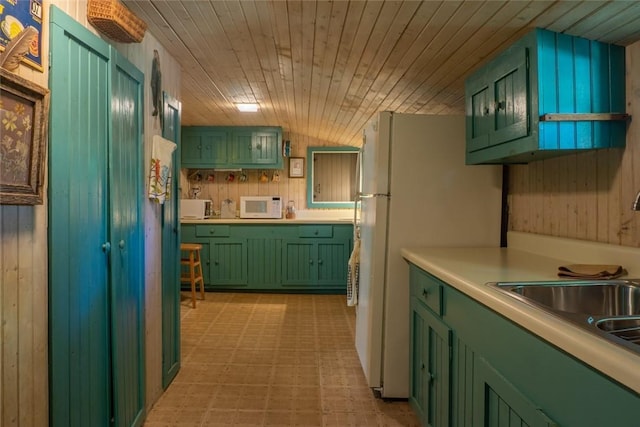 kitchen with white appliances, wooden walls, sink, wooden ceiling, and green cabinets